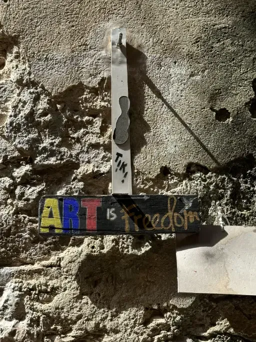 An installation on the walls of Bussana Vecchia stating “Art is Freedom”