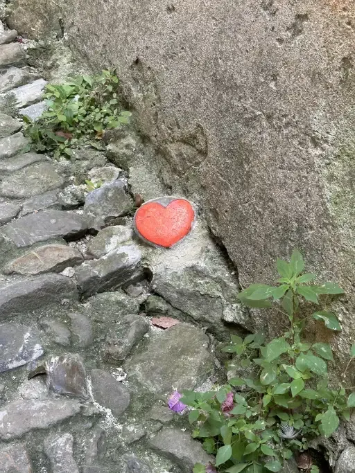 A little red painted stone heart on the floor of one of the small alleys in Bussana Vecchia