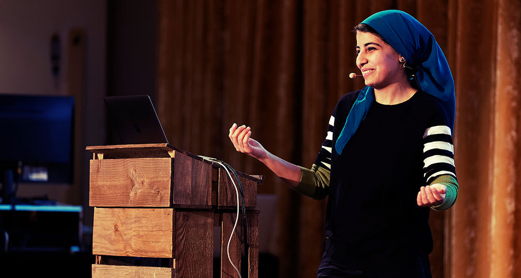 A photo showing dina speaking in Munich