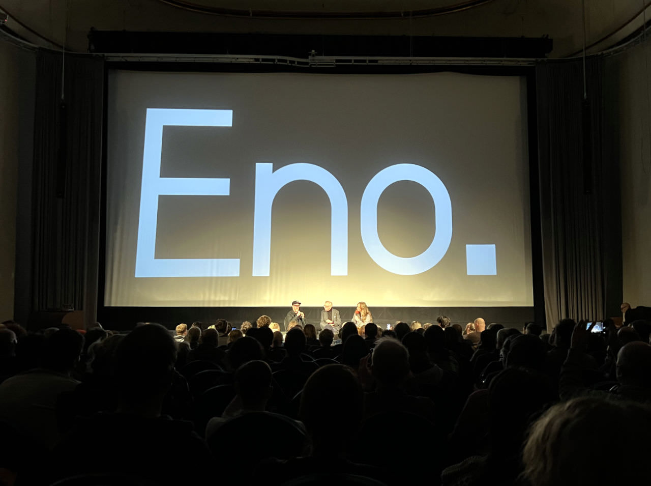 A photo from further away from the stage on which you can see Gary Hustwit, Brendan Dawes and me on stage at the Q&A behind many heads of the audience.