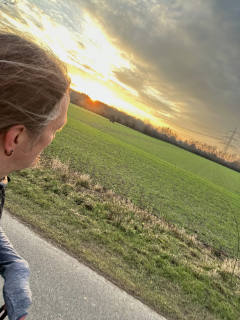 Me running . You can see me cut off at the left side of the photo and a green field in the back with the sun just rising.